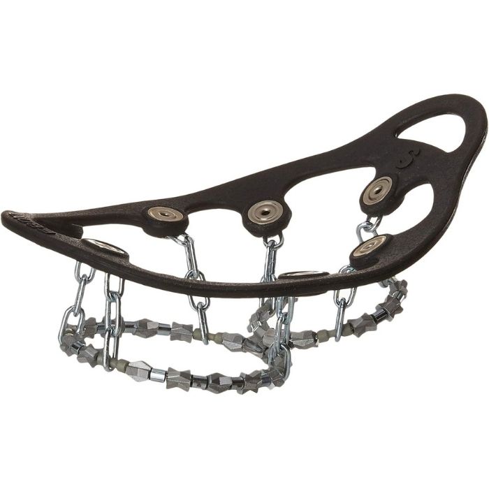 A person rinsing off a pair of Yaktrax Diamond Grip cleats with water to remove road salt